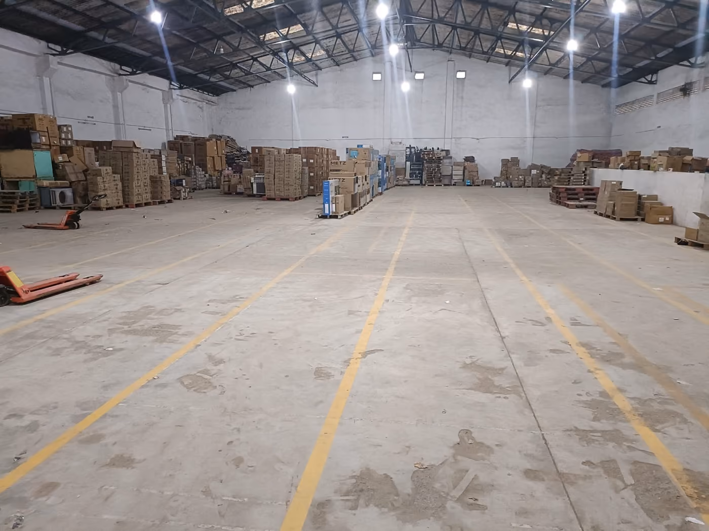 Inside Sanguine’s 15,000 sq. ft. warehouse in Chennai: marked floor bays, palletised stock and pallet trucks